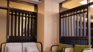 A modern room with a sofa, two armchairs, and a small table. - KANSEI Kyoto Hachijo (Kyoto)
