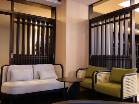 A modern room with a sofa, two armchairs, and a small table.