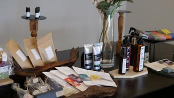 Una exhibición de diversos productos de belleza y bienestar, incluyendo artículos para el cuidado del cabello, un florero con flores y productos envasados ordenados.