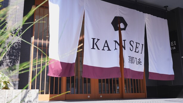 A building entrance with a large banner displaying the name "KANSEI" and some Japanese characters. - KANSEI Kyoto Hachijo (Kyoto)