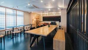 A modern conference room with a long table, multiple chairs, and a small seating area. - KANSEI Kyoto Hachijo (Kyoto)