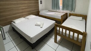 A room with two beds, a wooden headboard, a tiled floor, and a window with curtains. - Flamingo Beach Pousada (Cabo Frio)