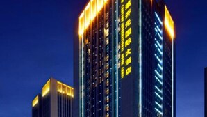 A high-rise hotel with illuminated signage and a modern architectural design.