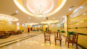 A spacious lobby with a high ceiling, chandeliers, and a central reception desk. - Yuehang Hotel (Zhuhai)