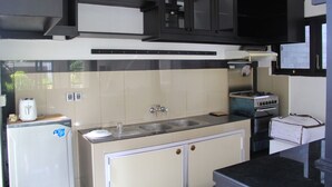 Una cocina compacta con refrigerador, estufa, pileta y alacenas.
