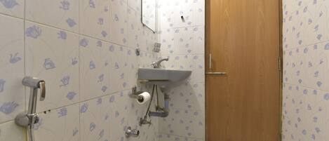 A bathroom with a toilet, sink, and shower.