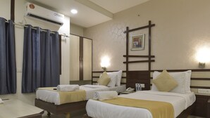 Une chambre d’hôtel avec deux lits, un bureau, un appareil de climatisation et un espace douche.
