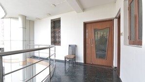 Un intérieur moderne avec une rambarde en verre, une porte en bois et un mur orné de motifs.