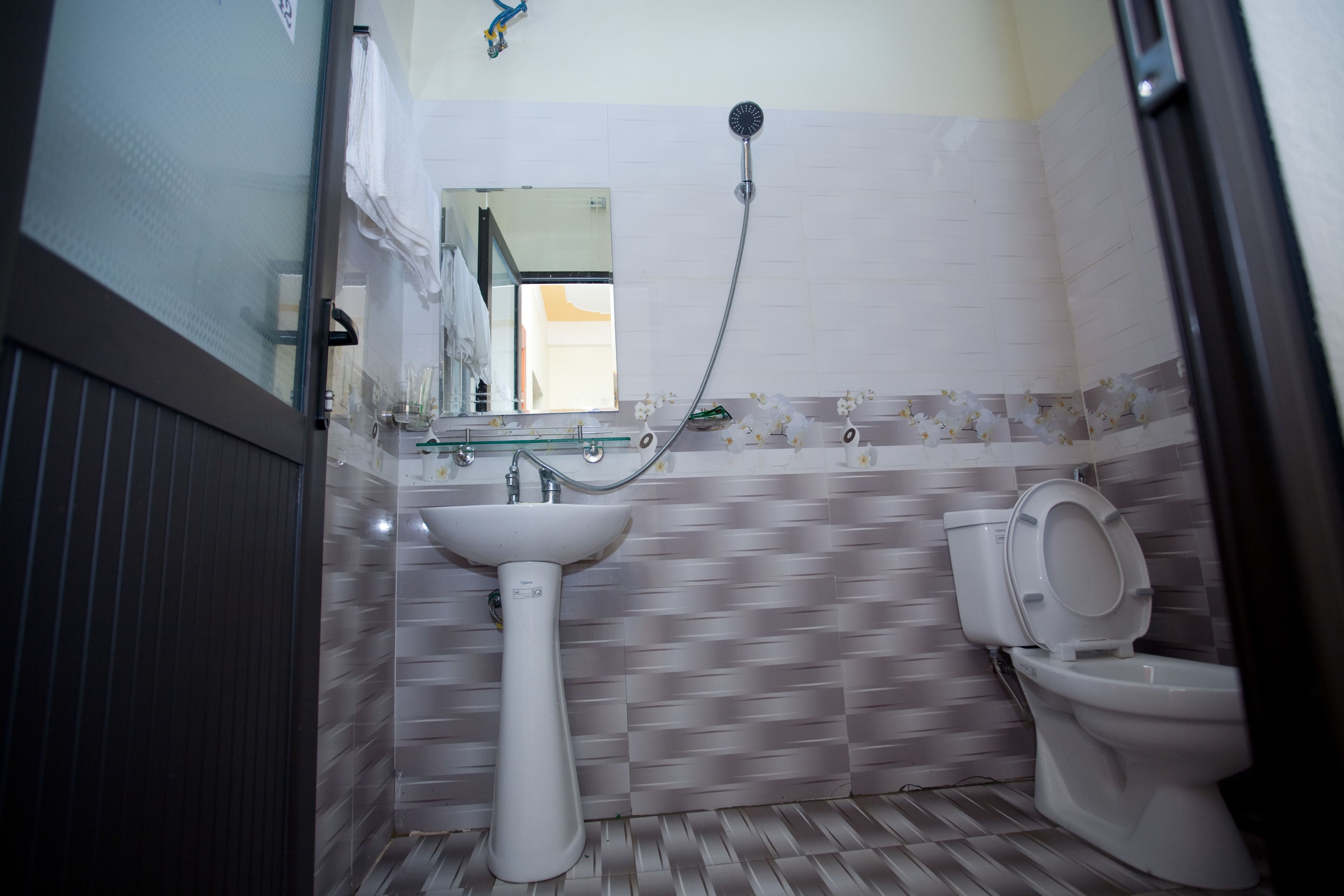 A bathroom with a white sink, a toilet, and a shower.