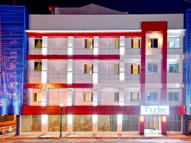 Un hotel de varios pisos con un diseño moderno, caracterizado por una llamativa combinación de rojo y blanco.