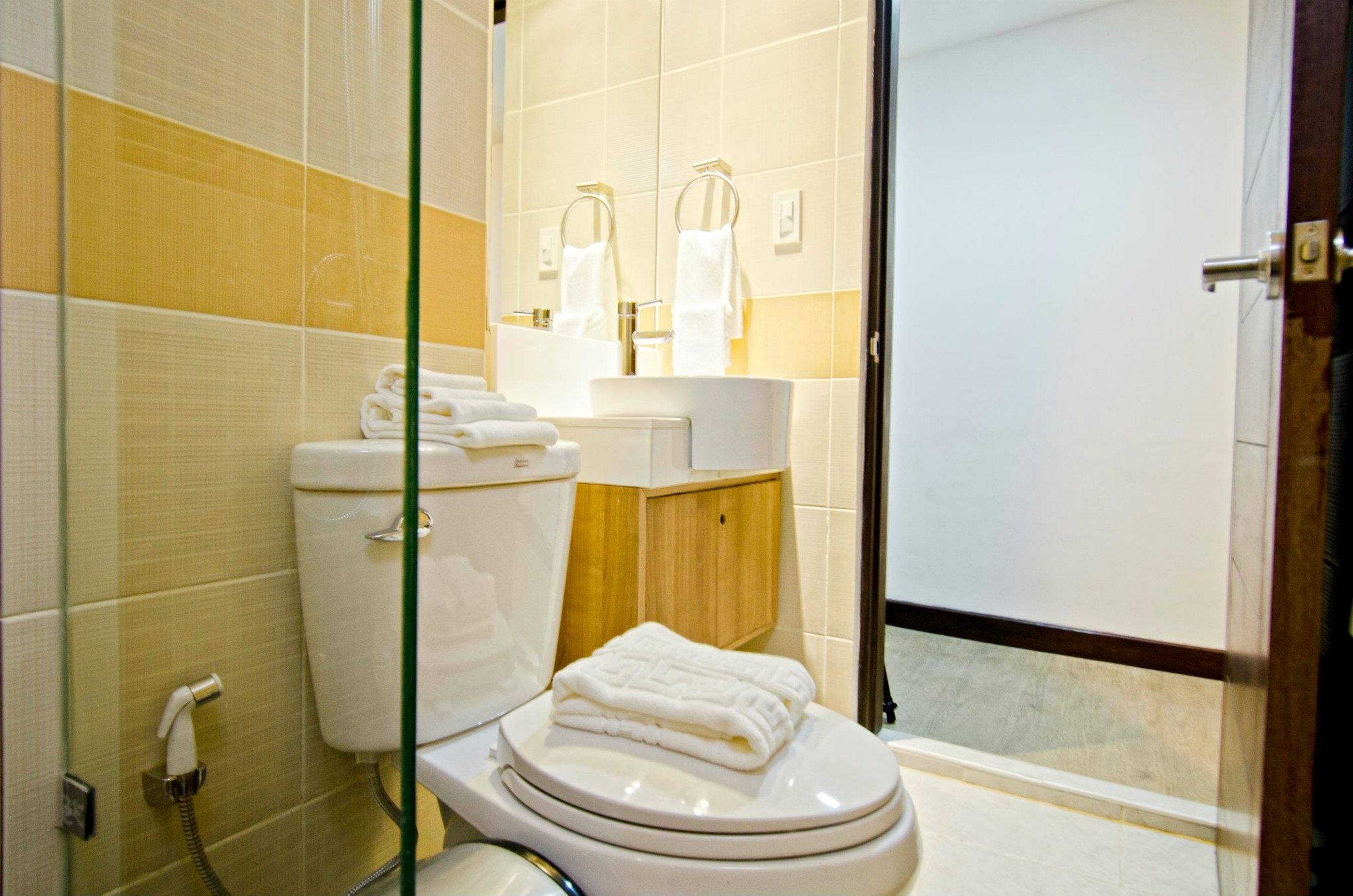 Un baño con inodoro, lavamanos y cabina de ducha de vidrio.