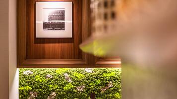 A framed photograph on a wooden wall, a green moss wall below, and a kitchen area with a sink and cabinets.