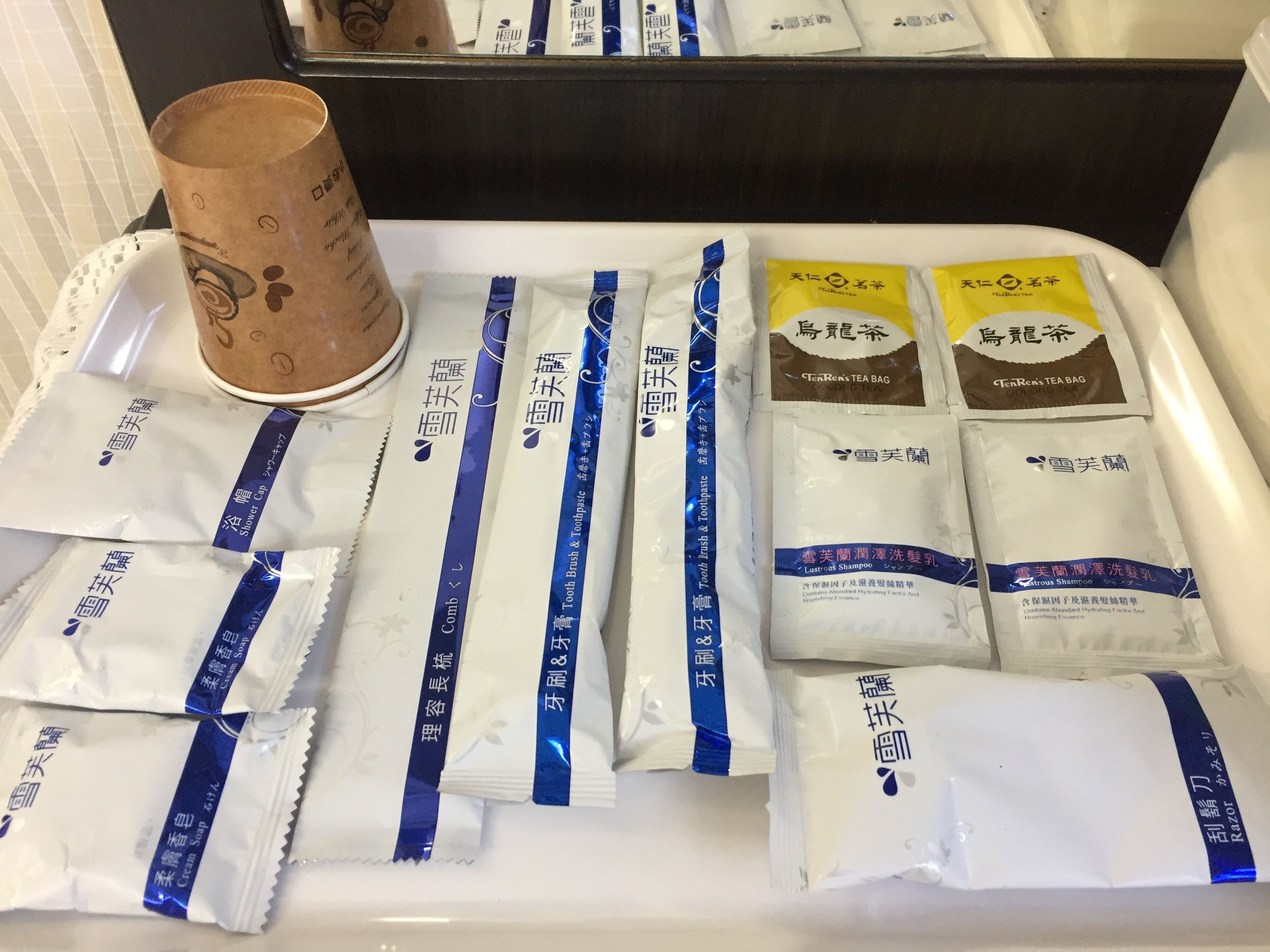 Ein Tablett mit verschiedenen Pflegeprodukten, darunter Zahnbürste, Zahnpasta und Shampoo.