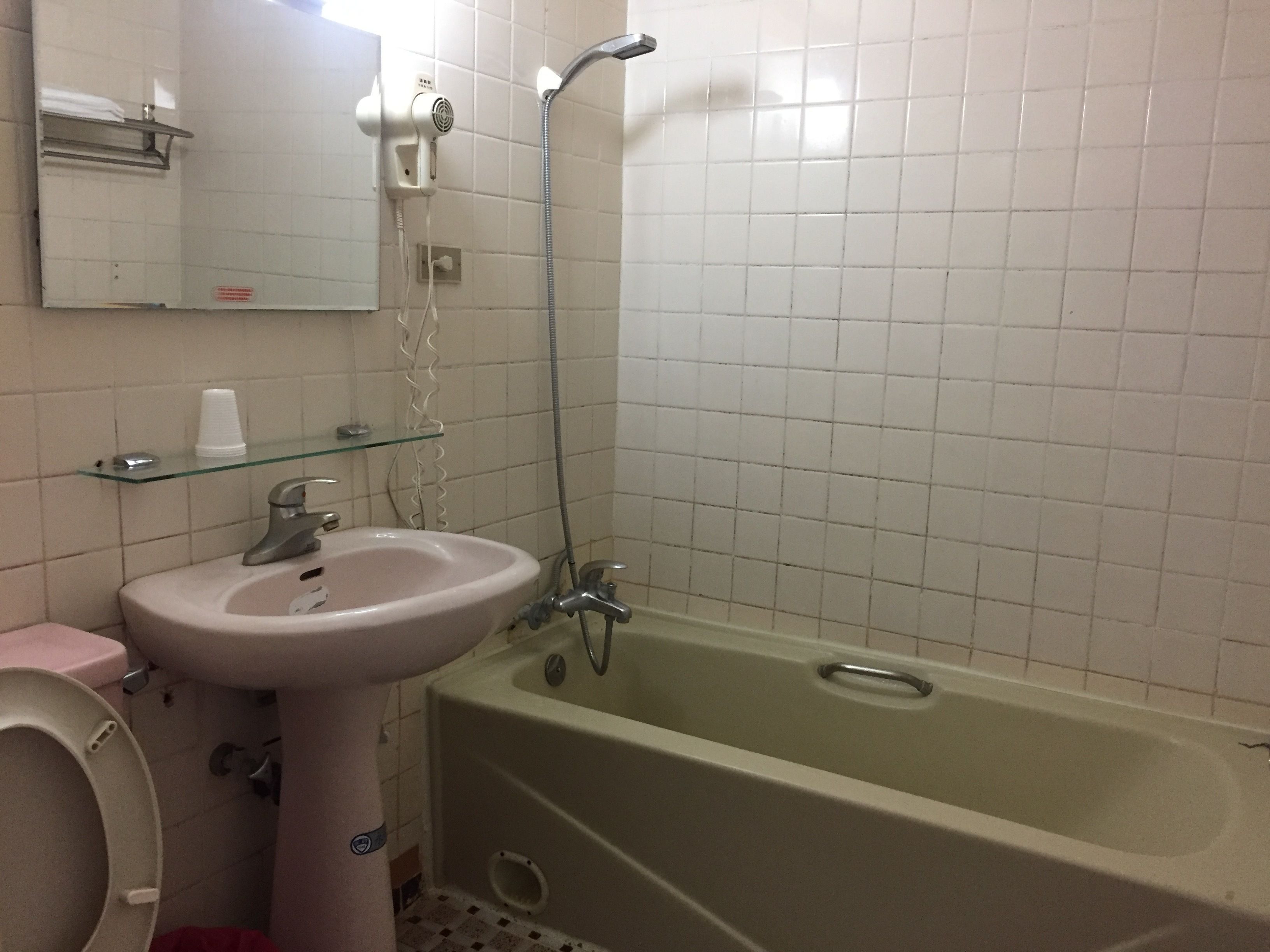 A bathroom with a sink, mirror, and shower.