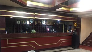 A reception desk with a telephone, a clock, and a decorative wall. - King Lo Tung Hotel (Luodong)
