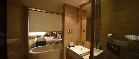 Une salle de bain moderne avec une baignoire, un lavabo et un grand miroir.