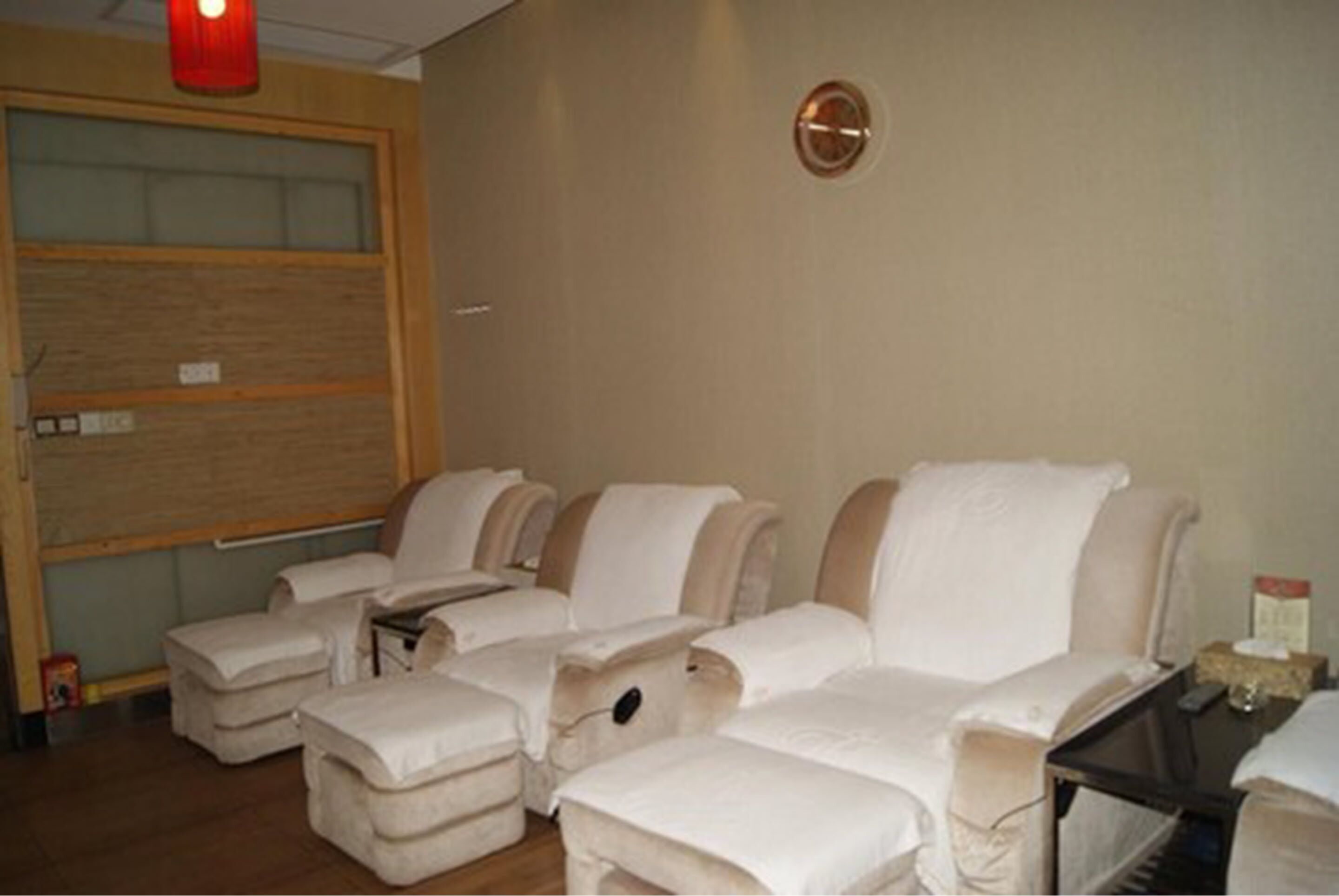 A room with massage chairs, a wooden door, and a small table with a tissue box.