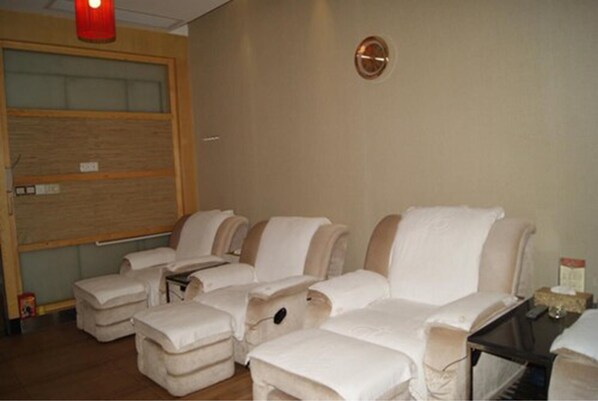 Habitación con sillones de masaje, una puerta de madera y una mesita con una caja de pañuelos.