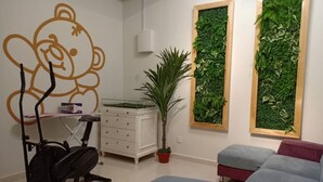A room with a treadmill, a desk, a potted plant, and two green vertical gardens. - BB Villas - 5 min Jonker Melaka (Malacca City)