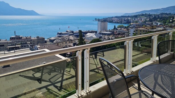 Ein Balkon mit Blick auf eine Küstenstadt, einschließlich Gebäude und eines Gewässers.