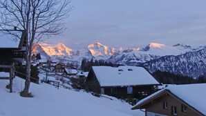 A snow-covered mountain village with traditional wooden houses and a view of snow-capped peaks in the background. - Beautiful apartment for 4 guests with WIFI, TV, balcony and panoramic view (Mauren)