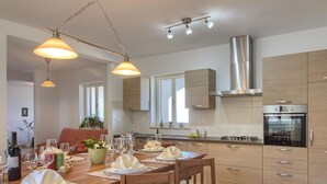 A modern kitchen with wooden cabinets, a stainless steel range hood, and an oven. - Wonderful private villa for 10 guests with private pool, WIFI, A/C, TV, terrace and pets allowed (Koromacno)