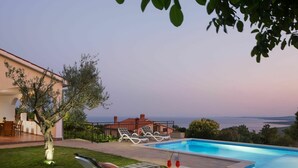 A poolside area with lounge chairs, a table with drinks, and a view of the sea. - Wonderful private villa for 10 guests with private pool, WIFI, A/C, TV, terrace and pets allowed (Koromacno)