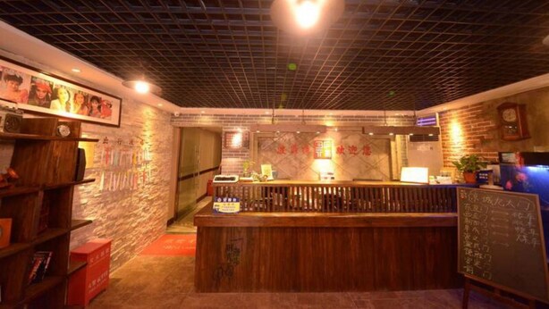 A restaurant interior with a wooden counter, brick walls, and a grid-patterned ceiling. - Beijing Perfect Inn Hotel (Beijing)