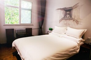 Un dormitorio con cama, radiador, ventana y un mural en la pared.
