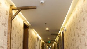 A long, narrow hotel corridor with patterned walls and a patterned carpet. - Beijing Perfect Inn Hotel (Beijing)