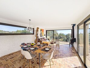 Un comedor con una mesa grande, sillas y vistas al exterior.