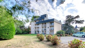 A multi-story building with balconies, surrounded by well-maintained lawns and shrubs. - Cosy apartment for 2 guests with WIFI, TV, balcony and pets allowed (Dinard)