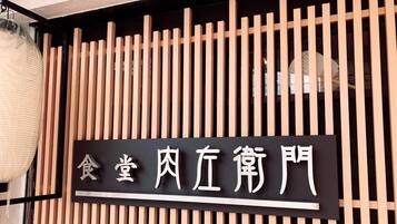 A sign with Chinese characters, mounted on a wooden slat wall.