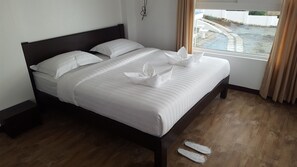 A neatly made bed with white linens and a decorative pillow arrangement. - Bikyeong Hotel and Restaurant (Tagaytay)