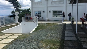 Um edifício branco com várias janelas e um espaço exterior vedado com uma pequena piscina.