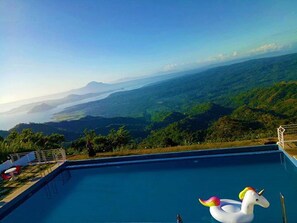 A swimming pool with a view of a mountainous landscape. - Bikyeong Hotel and Restaurant (Tagaytay)