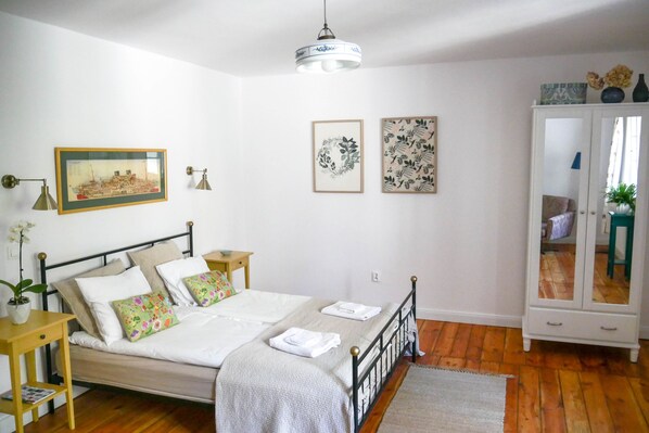 A neatly arranged bedroom with a bed, bedside tables, a wardrobe, and wall art. - Cocorico Apartments (Poznan)