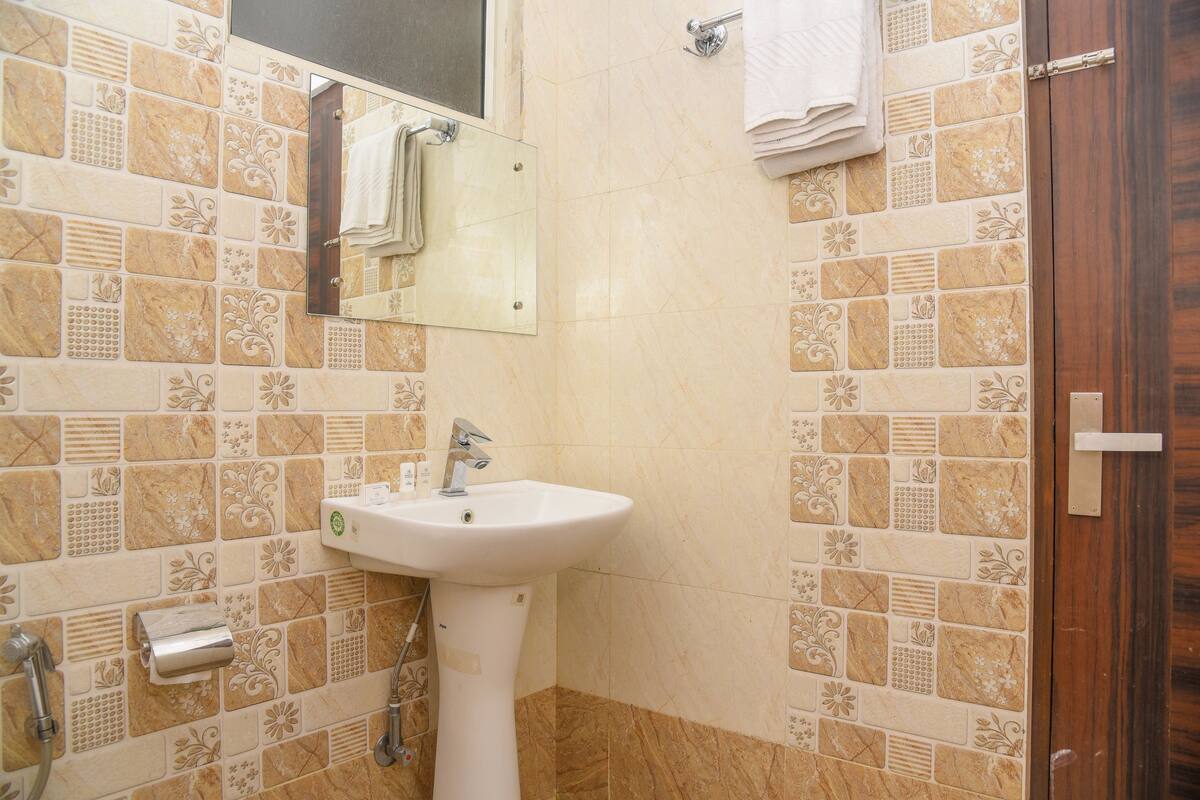A bathroom with a white sink, a mirror, and a towel rack.