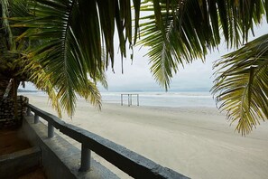 A beach with a concrete walkway and palm trees. - Mawar Villa (Kuantan)