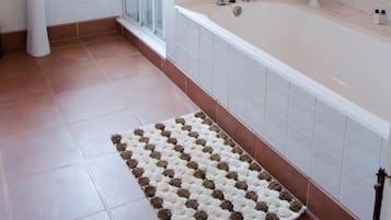 A bathroom with a white bathtub, a white sink, and a glass shower enclosure.
