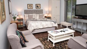 Ein Schlafzimmer mit einem Bett, Nachttischen, einem Fernseher, einem Sofa und einem Couchtisch.