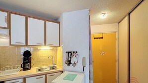 A compact kitchen with a coffee maker, sink, and a small refrigerator. - Cozy Apartment with Terrace, Near Spa and Town Center, Pet-Friendly, Free Parking, 24m² (Lamalou-les-Bains)