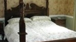 A four-poster bed with a wooden frame and a white bedspread. - Neuadd Arms Hotel (Llanwrtyd Wells)