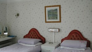 A room with two beds, a bedside table, a mirror, and a wall-mounted picture. - Neuadd Arms Hotel (Llanwrtyd Wells)