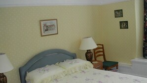 A bedroom with a bed, two bedside tables, a chair, and a nightstand. - Neuadd Arms Hotel (Llanwrtyd Wells)