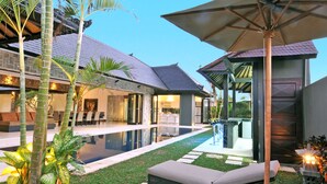A modern house with a swimming pool, outdoor seating, and a covered patio area. - Villa Samudra Raya (Seminyak)