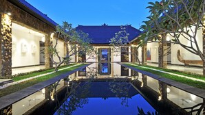 A courtyard with a central pool, stone walls, and modern lighting. - Villa Samudra Raya (Seminyak)