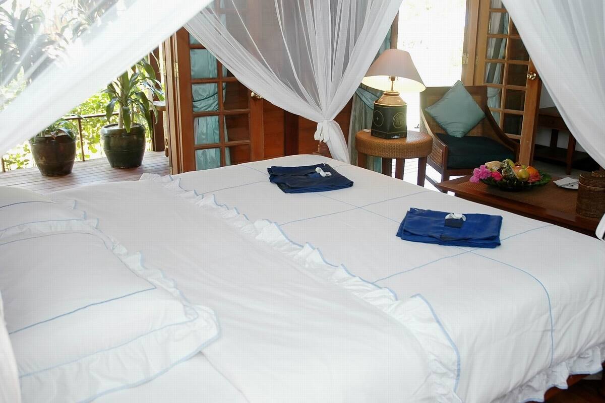 Bungalow Deluxe, vista al mar | Minibar, caja de seguridad en la habitación, escritorio y ropa de cama 
