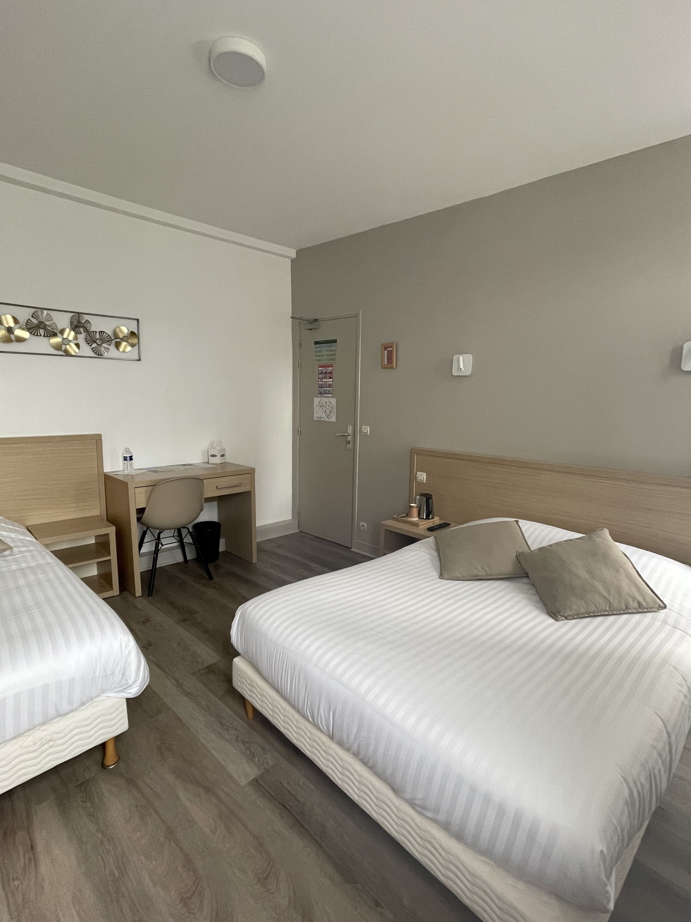 Una habitación de hotel con dos camas, un escritorio y una silla.