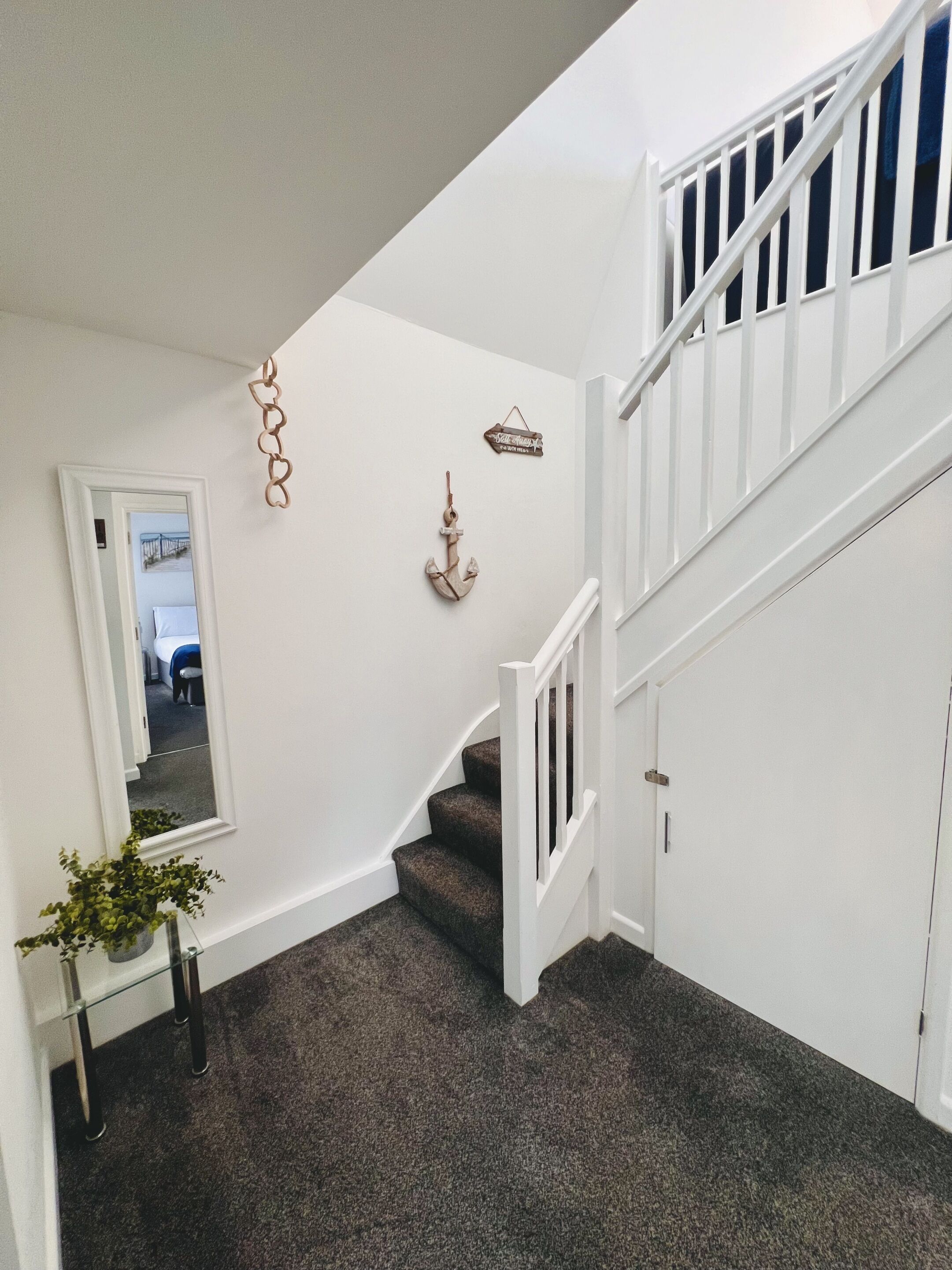 A staircase with white railings and carpeted steps leading to a landing.